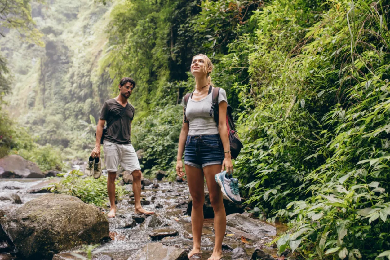 couple on forest hike grounding without shows by creek
